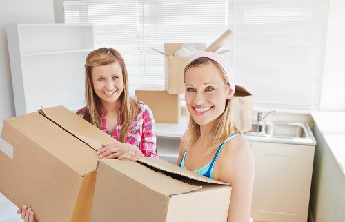Packed moving boxes and furniture ready for transport in Brent